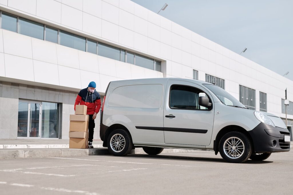 delivery man with boxes next to a white van